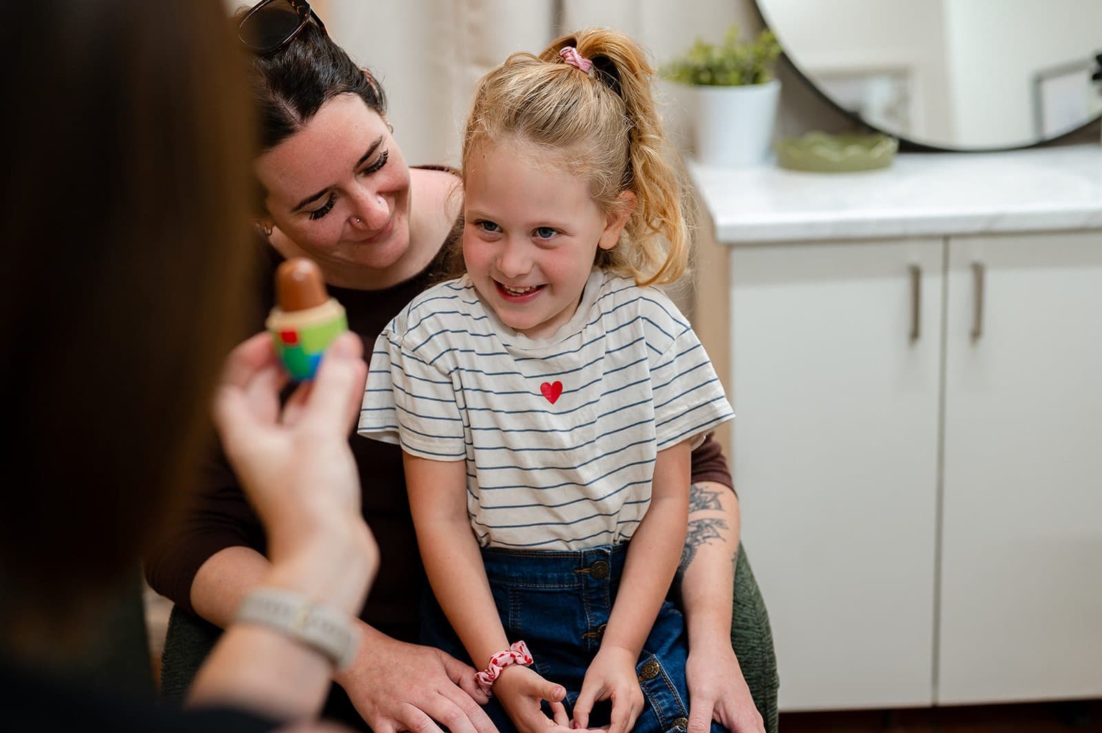 A child and her parent taking part in a playful hearing assessment at the Peak Hearing clinic