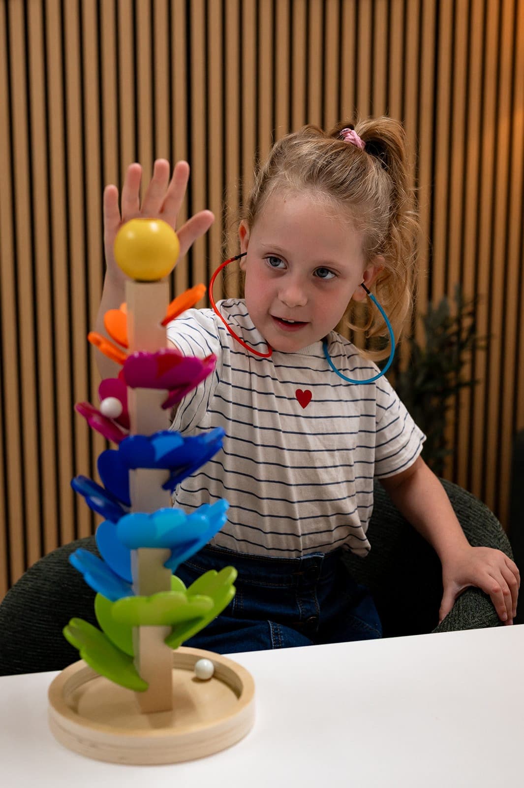 A child wearing insert earphones and responding during a play-based hearing assessment